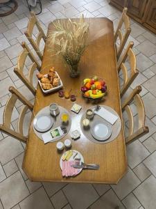 a table with a plate of food and a bowl of fruit at paddock pétillant in Auménancourt-le-Grand