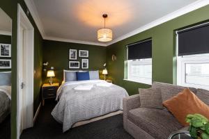 a green bedroom with a bed and a couch at Old Ship Inn Hackney in London