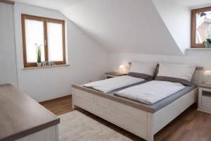 a bedroom with a bed with white walls and windows at Ferienhaus 147 in Sekull