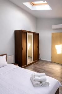 a bedroom with a bed with two towels on it at Nesto Rooms in Sighetu Marmaţiei
