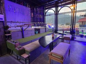 a purple room with a bar with a table and chairs at Hotel MM Inn in Rishīkesh
