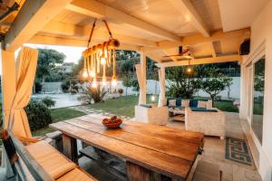 a patio with a wooden table and chairs at Villa Michaela con piscina privata e vista mare in Capo Vaticano
