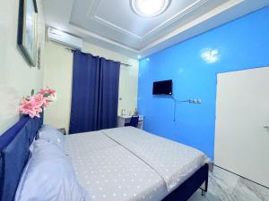 a blue bedroom with a bed and a blue wall at House & Food in Thiès