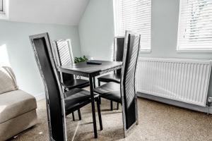a black table and chairs in a room at Family-Friendly Chorlton Apartment with Free Street Parking in Sale