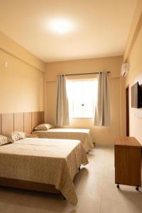 a bedroom with two beds and a window at Hotel Primavera Palace in Salinas +11 photos