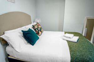 a bedroom with a white bed with pillows at Family-Friendly Chorlton Apartment with Free Street Parking in Sale +21 photos