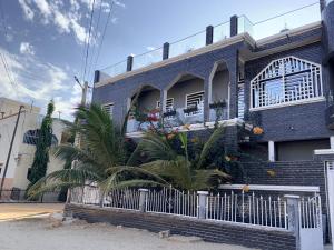 a black brick house with palm trees in front of it at House & Food in Thiès
