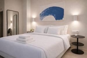 a bedroom with a large white bed with towels on it at Roca Collection MSuites in Valencia +2 photos