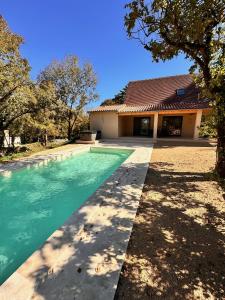 a swimming pool in front of a house at Gîtes du Point de Vue & du Causse d'Autoire in Autoire