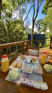 a table with plates of food and drinks on it at Chalé Malbec, Estrada do Vinho com cafe da manha e hidro in São Roque