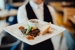 a person holding a plate with food on it at Banícky dom Siglisberg in Banská Štiavnica