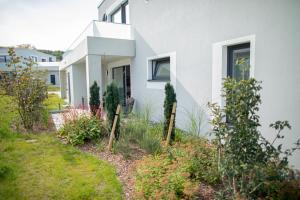 a white house with a garden in front of it at Zweite Heimat Apartment 2 in Lohme