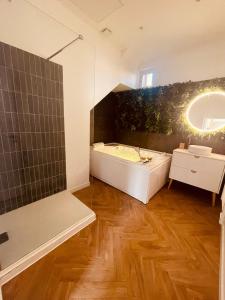 a bathroom with a tub and a sink and a mirror at Le Jungle SPA **** in Nîmes +20 photos