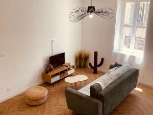 a living room with a couch and a table at Le Jungle SPA **** in Nîmes