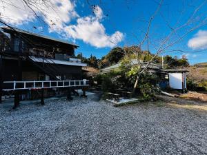 a house with a bench in front of it at Bungee Inn in Minamiizu