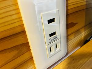 an electrical outlet on the side of a wall at Bungee Inn in Minamiizu