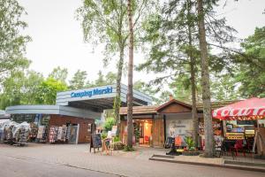 a store with a sign that readsancy habitat next to trees at Camping Morski 21 in Łeba