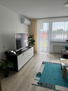 a living room with a flat screen tv on a white cabinet at Apartment 4 rooms 'Bauer' in Korfantów