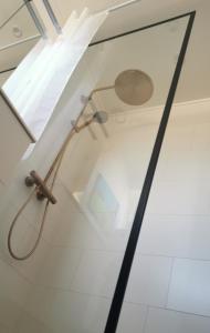 a shower with a glass door in a bathroom at TheGilgahouse Gardenroom nr 2 in Nakskov