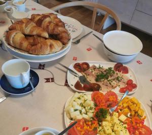 a table with plates of food and a plate of bread at TheGilgahouse Gardenroom nr 2 in Nakskov +17 photos