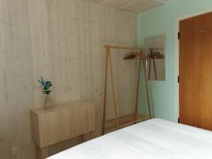 a bedroom with a white bed and a wooden closet at TheGilgahouse Gardenroom nr 2 in Nakskov