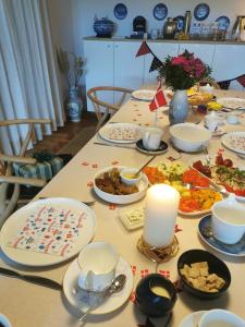 a long table with plates of food on it at TheGilgahouse Gardenroom nr 2 in Nakskov