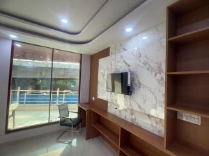 a room with a wall with a tv and a chair at Sai Sansthan Inn in Lucknow +19 photos