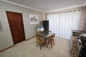 a kitchen with a table and chairs in a room at Work, Rest, Repeat, Comfortable 2BR Flat in Kathu in Kathu