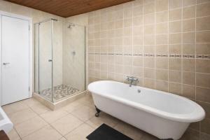 a bathroom with a bath tub and a shower at Work, Rest, Repeat, Comfortable 2BR Flat in Kathu in Kathu