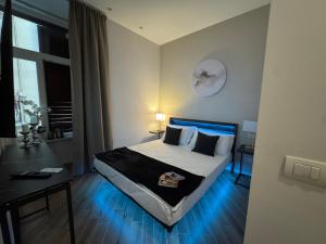 a bedroom with a large bed with a blue light at MILUAR Relais - Piazza Fuga in Naples