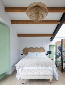 a bedroom with a white bed with a wooden ceiling at El Sueño, La Perla in Barres