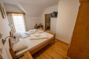 a bedroom with a bed with white sheets and towels at Anivina - B&B in Ivanjkovci