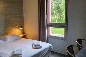 a bedroom with a bed and a window with towels at Chambres de séjour et Brasserie du Coiroux in Aubazines