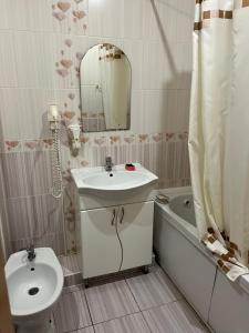 a bathroom with a sink and a toilet and a mirror at Міні готель вулиця Чавдар in Kyiv