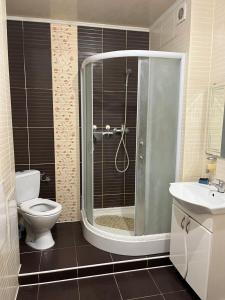 a bathroom with a shower and a toilet and a sink at Міні готель вулиця Чавдар in Kyiv