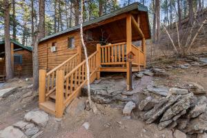 a cabin in the woods with a large wooden porch at Timber Ridge Cabin: Rustic Getaway in Rapid City