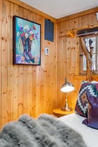 a bedroom with a bed and a painting on the wall at Timber Ridge Cabin: Rustic Getaway in Rapid City