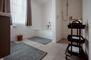 a bathroom with a tub and a towel rack at Okelmann's - Eco Hotel & Appartements in Warpe +84 photos