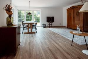 a living room with a table and a dining room at Okelmann's - Eco Hotel & Appartements in Warpe
