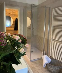 a bathroom with a shower and a vase of flowers at da Tony home B&B in Tarzo +41 photos