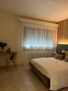 a bedroom with a large bed and a window at da Tony home B&B in Tarzo