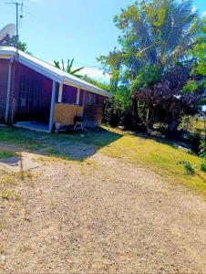 a house with a dirt yard next to a house at Le temps d'une pause in La Foa