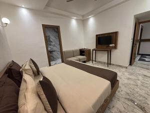 a bedroom with a large bed and a television at Serenity By The Ganges in Haridwār