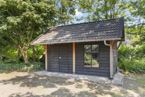 a small cabin with a window in a yard at Boerderij appartement 't Vogelnest in Heiloo