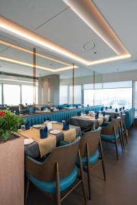 a dining room with tables and chairs and windows at Airotel in Pune