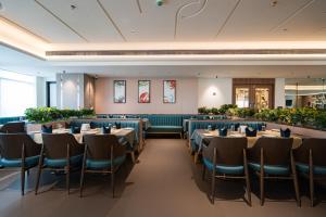 a restaurant with tables and chairs in a room at Airotel in Pune
