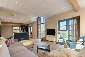 a living room with a couch and a flat screen tv at Boerderij appartement 't Vogelnest in Heiloo