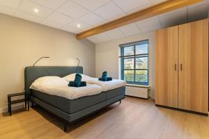 a bedroom with a bed and a large window at Boerderij appartement 't Vogelnest in Heiloo