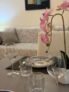 a table with glasses and a vase with a flower on it at Suite romantica a Como Centro in Como