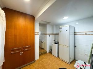 a kitchen with white walls and brown cabinets and a refrigerator at Villa Las Palmas in Benicàssim